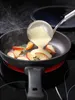 A ladle pouring batter into a frying pan with apple slices. Produktbild-Vorschau