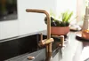A close-up shot of a modern kitchen faucet and sink. Podgląd zdjęcia produktu