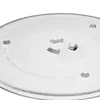 A close-up view of a transparent glass microwave turntable plate with three small gray support feet visible. Produktbild-Vorschau