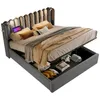 A grey upholstered bed with its storage compartment open, revealing stored items. Produktbild-Vorschau
