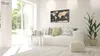 A modern living room with a white sofa, a coffee table, and a large window overlooking a garden. A world map metalboard is hanging on the wall. Náhľad obrázku produktu