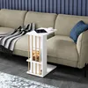 A white side table with wooden accents is placed next to a beige sofa in a living room setting. A blanket is draped over the sofa, and a tablet and a cup of coffee are on the table. Náhľad obrázku produktu