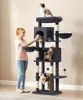 A woman is interacting with a multi-level cat tree that has several cats on it. Produktbild-Vorschau