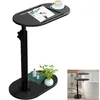 A black C-shaped side table with a magazine and coffee cup on top, and decorative items on the base. A smaller inset image shows the table next to a bathtub. Produktbild-Vorschau