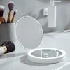 A makeup mirror with LED lighting and makeup brushes on a bathroom counter. Produktbild-Vorschau