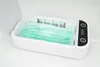 A green face mask is placed inside a white UV sterilizer box. Produktbild-Vorschau