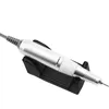A silver and white electric nail drill is resting on a black stand against a white background. Produktbild-Vorschau