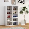 A white shoe rack filled with various shoes, placed next to a potted plant and a shopping bag. Produktbild-Vorschau