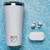 A white tumbler and white wireless earbuds are laid out on a blue, wavy background. Náhľad obrázku produktu