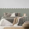 A bedroom scene with a bed, pillows, blankets, and a wall decal. Podgląd zdjęcia produktu