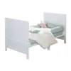 A white baby crib with bedding and pillows. Produktbild-Vorschau