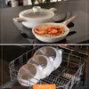 A collage showing a cooking pot and pan on a stovetop, and then the pans stacked in a dishwasher. Produktbild-Vorschau