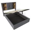 A grey upholstered bed frame with its mattress support raised, revealing storage space underneath. The headboard features built-in shelving. Náhľad obrázku produktu