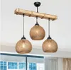 A chandelier with three woven globe-shaped lamps hanging from a wooden beam. Náhled obrázku produktu