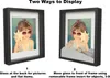 Two shadow boxes are shown side-by-side, demonstrating different ways to display items within them. The left box shows a photograph of a child with a seashell. The right box shows the same photograph but with sand and a hand-like object placed in front of  Náhled obrázku produktu