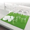 A dish drying mat with various glasses and plates on it, placed next to a sink. Náhľad obrázku produktu
