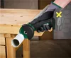 A person wearing a glove is using a cordless angle grinder to cut a white pipe on a wooden workbench. Produktbild-Vorschau