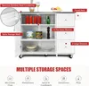 A white kitchen island with a stainless steel countertop, featuring multiple storage options like shelves and drawers, with labels pointing out its features. Náhľad obrázku produktu