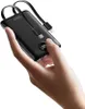 A hand holding a black power bank with integrated cables. Produktbild-Vorschau