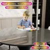 A young boy is drawing on a piece of paper placed on a round table. There are colorful markers lined up on the paper. The table is covered with a protective, transparent sheet. Anteprima dell’immagine prodotto