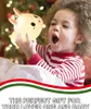 A young child is excitedly holding a glowing bunny-shaped night light in front of a Christmas tree. Produktbild-Vorschau