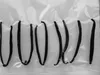 Several vanilla beans are laid out on a textured white or light gray background, possibly inside a vacuum-sealed bag. Náhľad obrázku produktu
