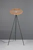 A floor lamp with a woven shade on a tripod base against a gray background. Produktbild-Vorschau