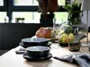 A table setting with bowls, bread, pears, and wine glasses. Produktbild-Vorschau