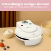 A white waffle maker is shown on a table with a bowl of whipped cream, strawberries, and blueberries, suggesting a breakfast or dessert setting. Produktbild-Vorschau