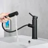 A hand is holding a black faucet sprayer over a white sink, with water flowing into the sink. Anteprima dell’immagine prodotto
