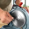 A close-up shot of a person's hands using a tool to adjust a circular saw blade. Voir les images du produit