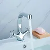 A chrome faucet with water running into a white sink, with a bar of pink soap on a wooden soap dish. Náhled obrázku produktu