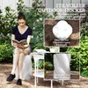 A woman is sitting on a white stool in a garden, reading a book. The stool is white and has a spiral design. There are plants and flowers in the background. There are also inset images showing details of the stool. Anteprima dell’immagine prodotto