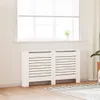 A white radiator cover is placed in front of a window with blinds. Podgląd zdjęcia produktu