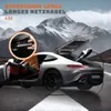 A silver sports car is parked on a road with mountains in the background. The car's doors and trunk are open, and a charging cable is connected to the trunk. A close-up inset shows a hand plugging a device into a car's power outlet. Produktbild-Vorschau