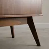 A close-up view of the wooden leg and base of a sideboard. Produktbild-Vorschau