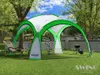 A green and white event pavilion set up in a grassy backyard with trees and a fence in the background. Produktbild-Vorschau
