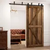 A wooden barn door is shown partially open, revealing a living room with a leather sofa and coffee table. Produktbild-Vorschau