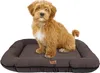 A small, fluffy, light brown dog sits on a dark brown dog bed. Náhled obrázku produktu