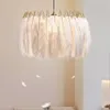 A white feather pendant light with a gold frame hangs in a room. Podgląd zdjęcia produktu