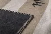 A close-up view of a blanket with stripes and a stitched edge. Produktbild-Vorschau