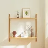 A wooden shelf mounted on a white wall, decorated with various items. Voir les images du produit