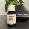 A bottle of essential oil is placed on a surface in front of a diffuser. Produktbild-Vorschau