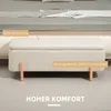 A storage bench with wooden legs placed in front of a bed. Voir les images du produit