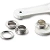 A set of metal eyelets and rings with a white plastic tool on a white background. Anteprima dell’immagine prodotto
