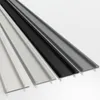 Four long, narrow strips of material in different colors (white, black, and two shades of gray) are arranged diagonally on a white background. Produktbild-Vorschau