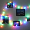 A string of colorful LED lights draped around framed pictures on a wall. Produktbild-Vorschau
