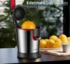A close-up of a stainless steel juicer with an orange inside, surrounded by lemons and a cup. Produktbild-Vorschau
