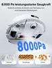 The underside of a white robot vacuum cleaner is shown, with blue text indicating suction power and three small images of debris it can clean. Produktbild-Vorschau