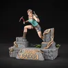 A statue of Lara Croft from Tomb Raider, posed dynamically on a ruined stone base. Anteprima dell’immagine prodotto